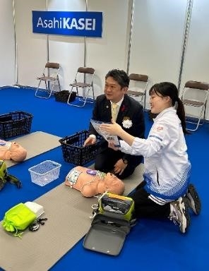 胸骨圧迫体験会に参加するスーツの男性